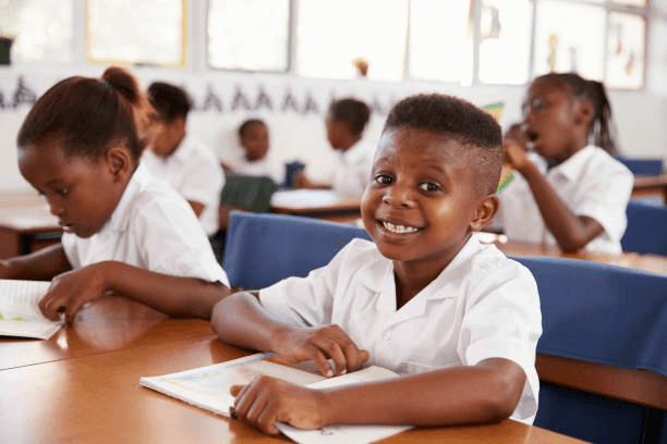 Smiling learner in uniform during a Grade R–7 class moment at Asamaths Institute